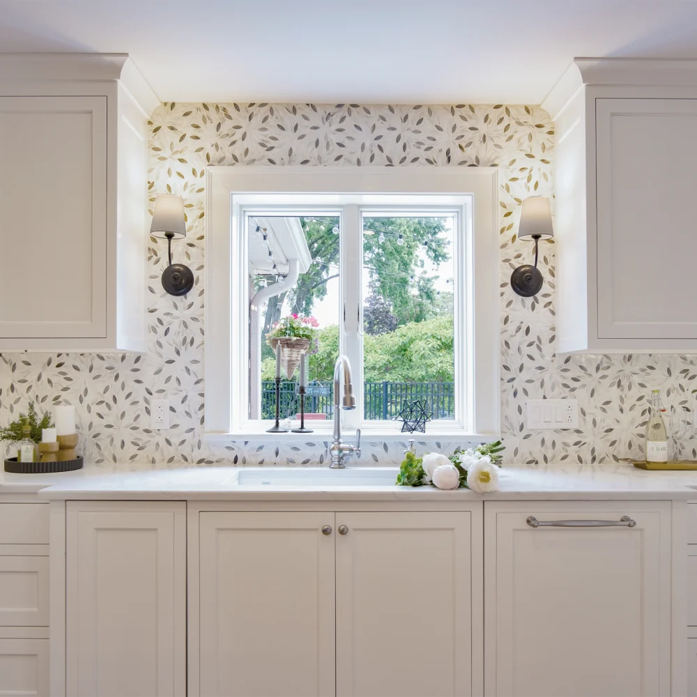 Cream cabinetry leaf backsplash double sink, featured in a recent kitchen remodel.