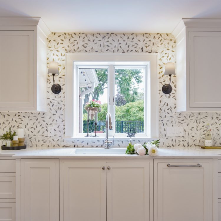 Cream cabinetry leaf backsplash double sink, featured in a recent kitchen remodel.